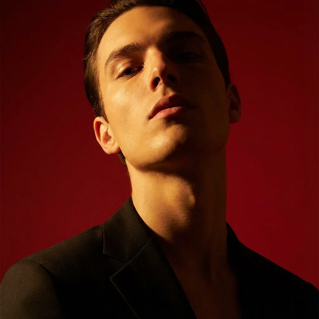 Vertical portrait shot in 9:16 format with intense contrast and a deep crimson red background